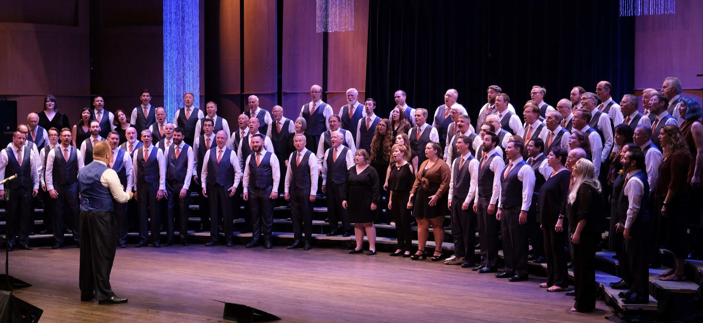 The Harmonizers with Metro Voices on risers performing together.